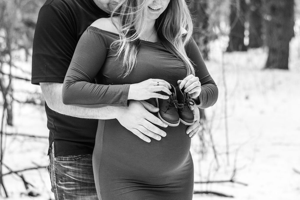 Couple embracing outdoors in winter, holding a small object together.