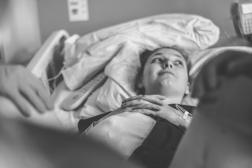 Patient lying in a hospital bed, staring upward with hands clasped on their chest