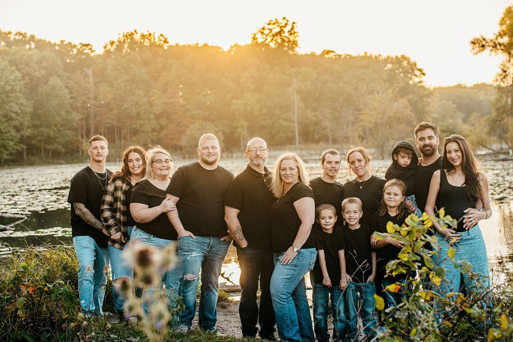 Group of people standing together in a sunlit field with trees in the background