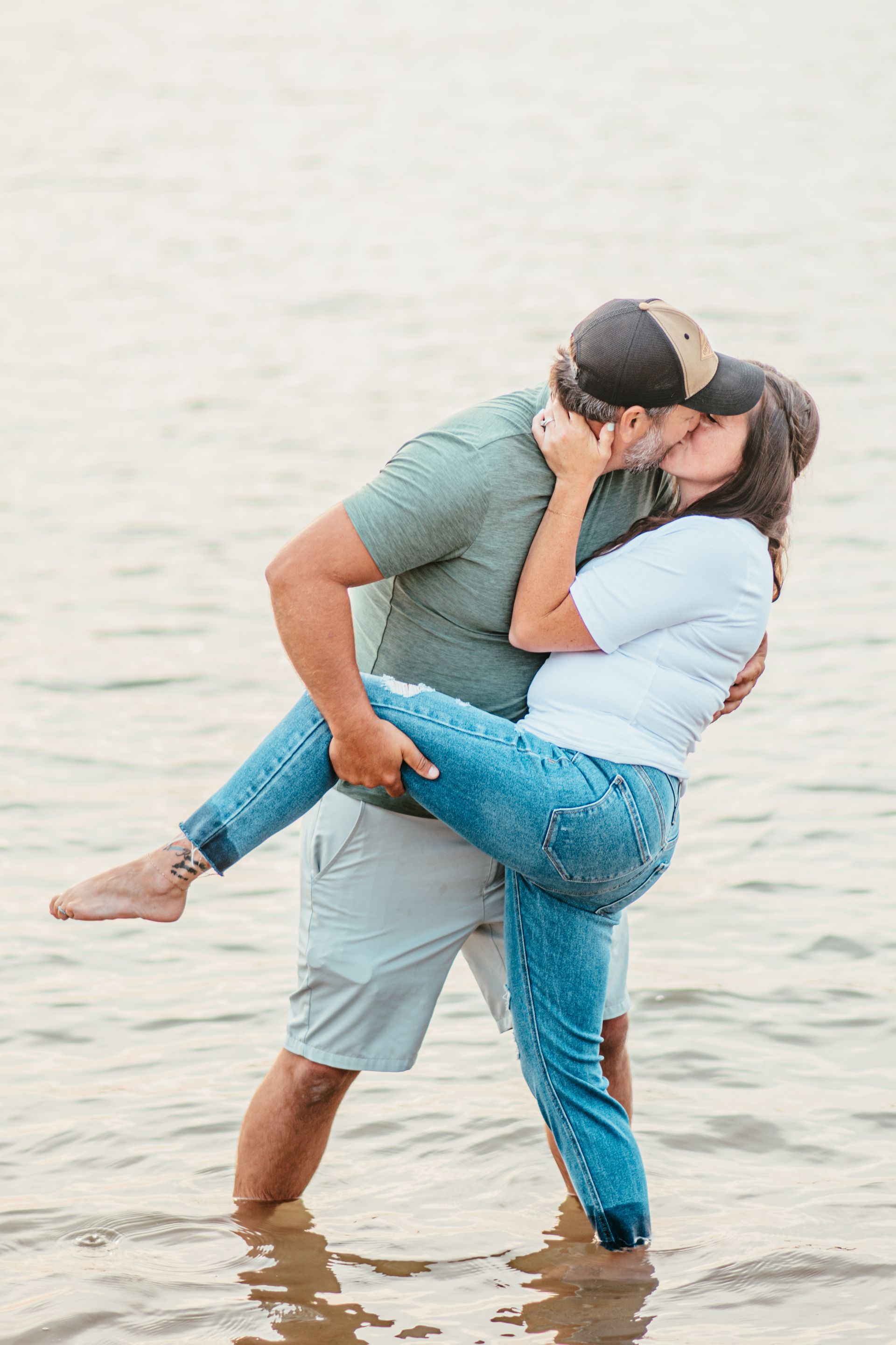 Couple kissing while embracing in shallow water at the beach