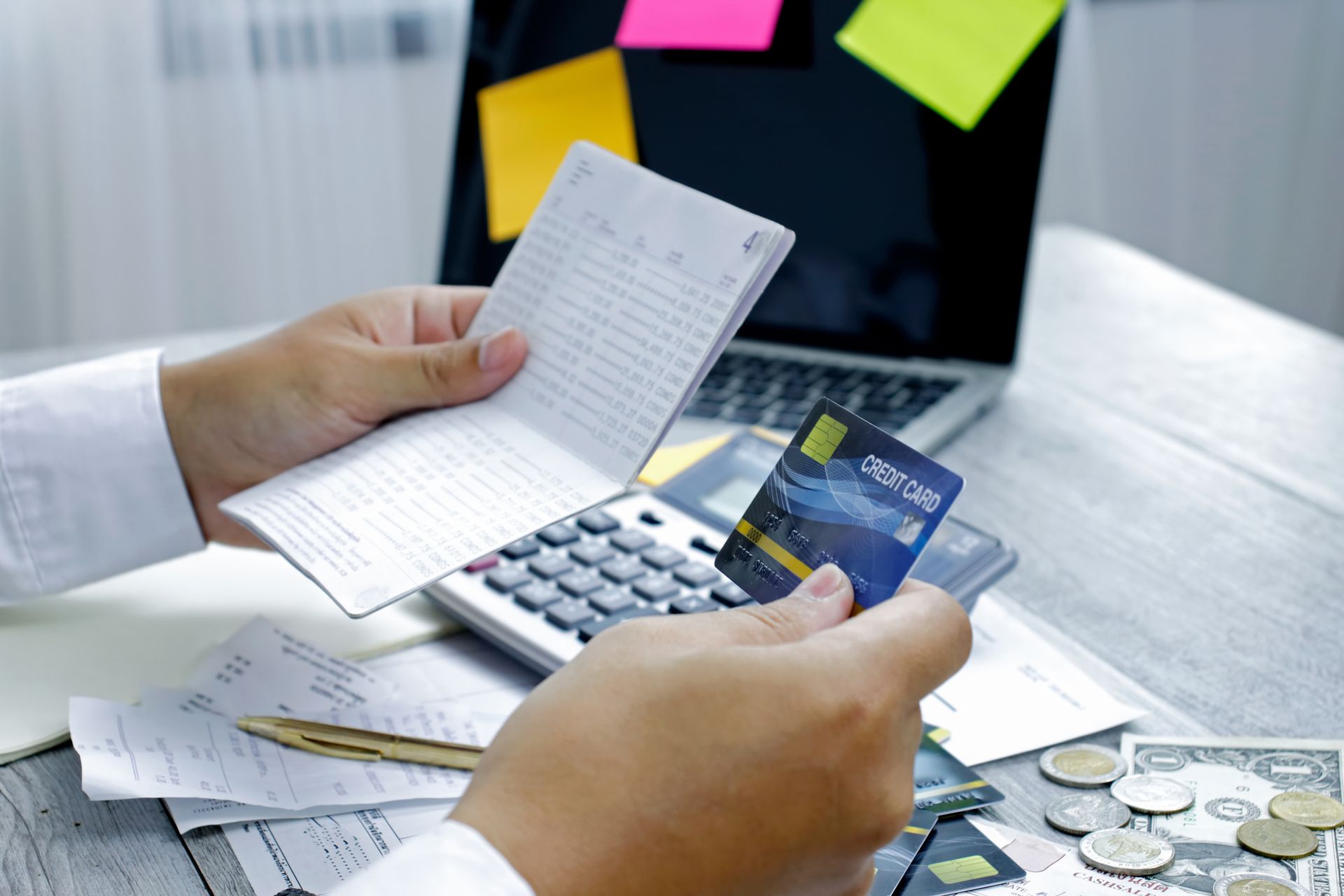 A person is holding a credit card and a calculator.