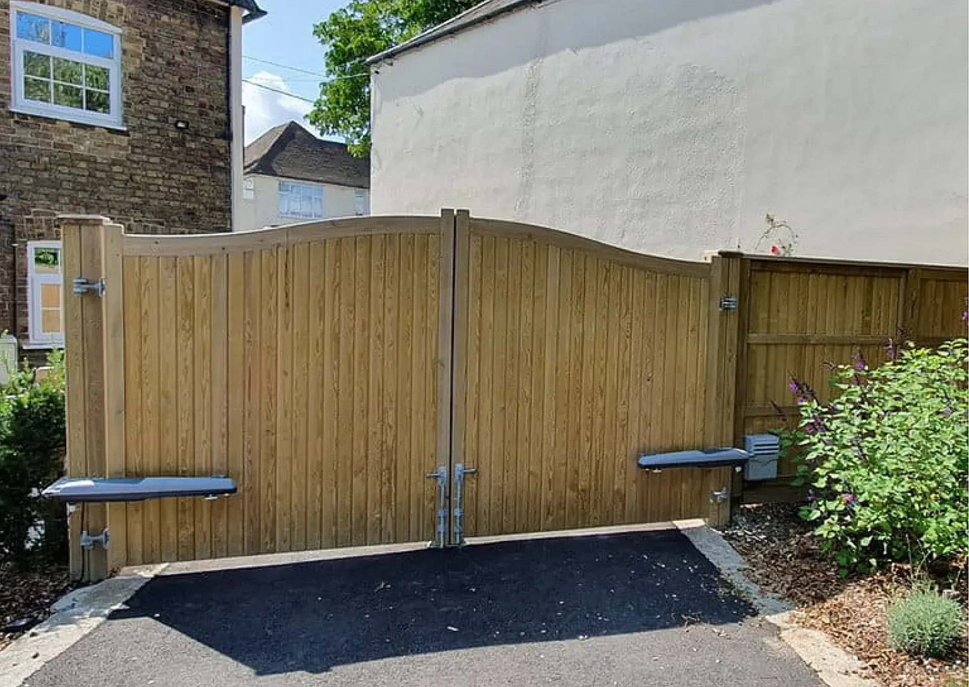 Double-leaf arched timber driveway gates featuring heavy-duty automated opening arms installed in Barnton, Edinburgh
