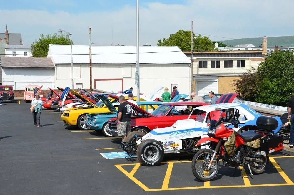 Row of colorful sports cars and motorcycles parked in a lot on a sunny day | Hermansaders Garage & Auto Sales