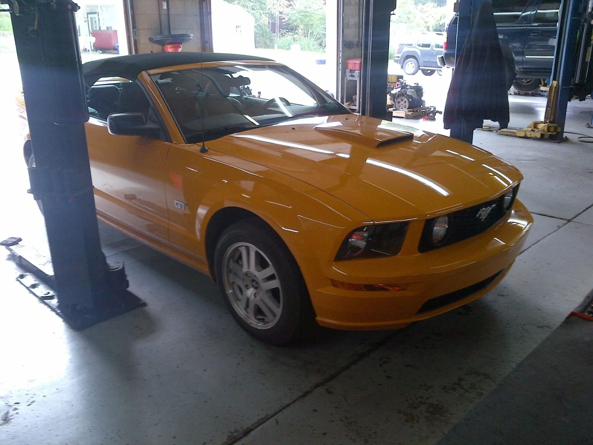 Orange sports car parked under a covered area near a sidewalk | Hermansaders Garage & Auto Sales