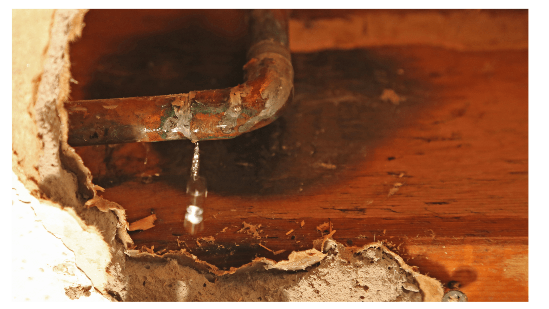 Image of water drop leaking from copper pipe behind wall