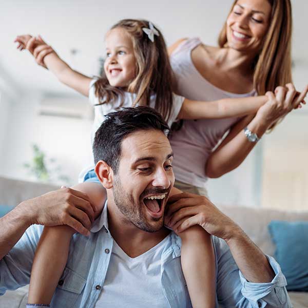 Couple with a young daughter playing inside a house