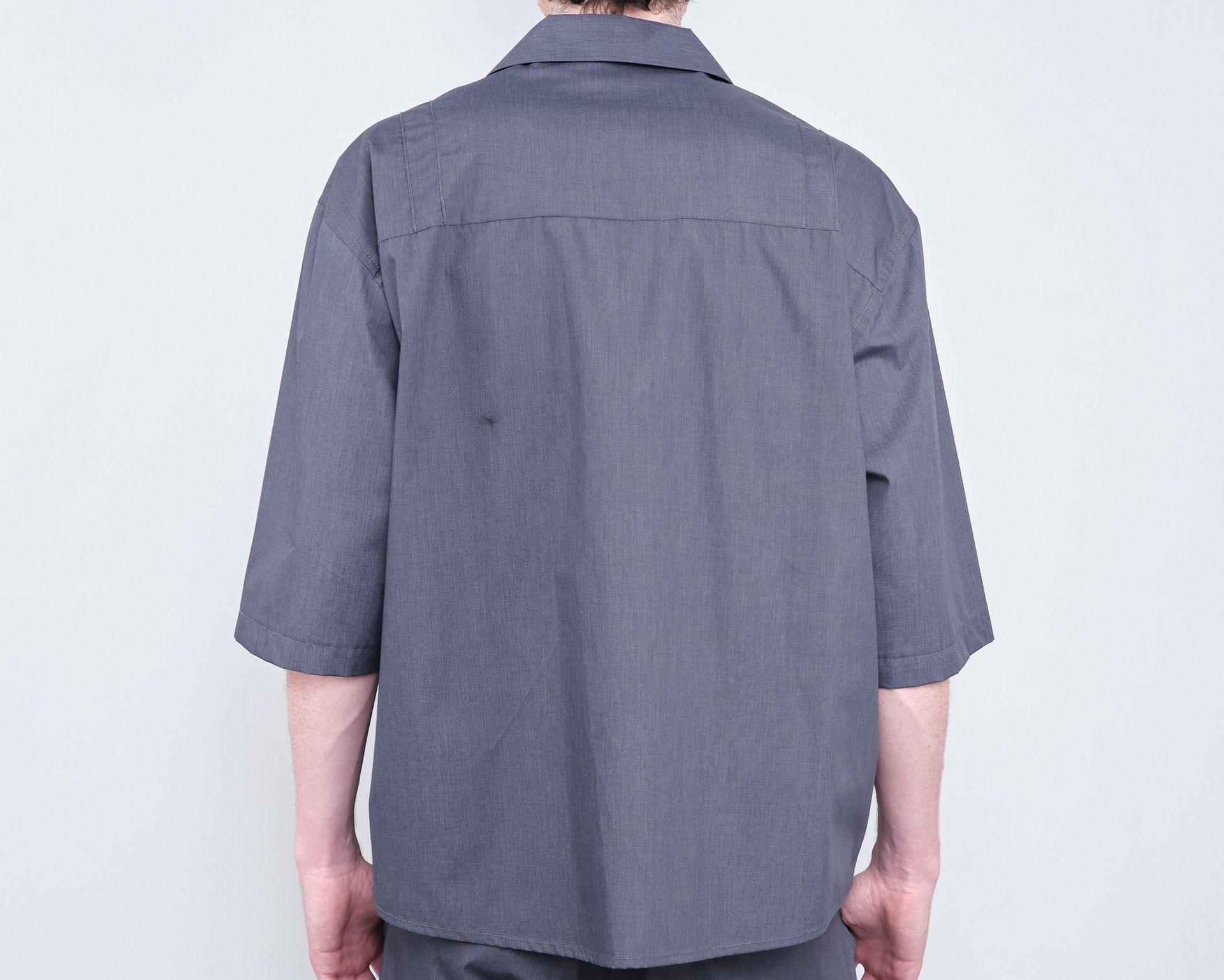 The back of a man wearing a grey shirt