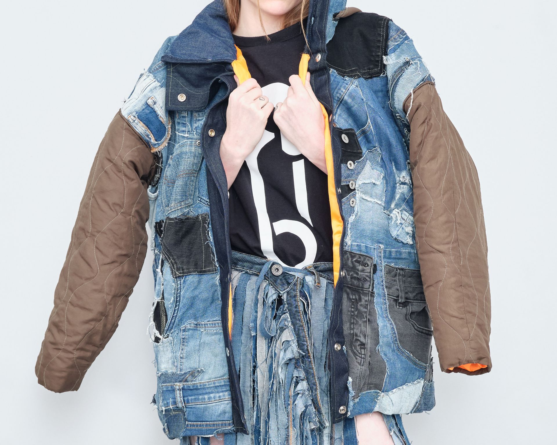A woman wearing a denim jacket and a skirt with the number 6 on it