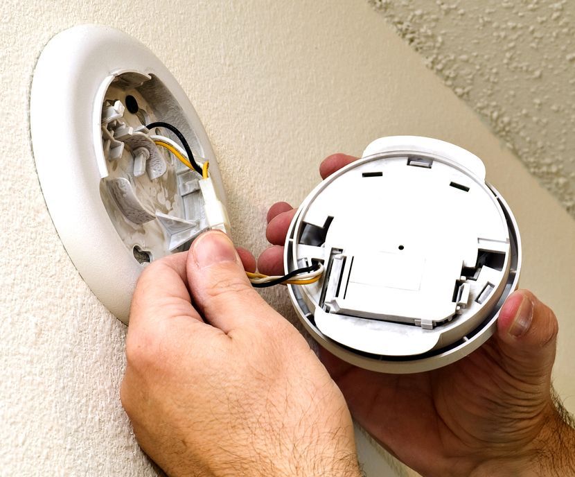 Smoke Alarm Being Repaired On The Wall — Alert Smoke Alarm Compliance in Maryborough, QLD