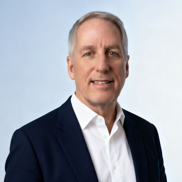 A man in a suit and tie is smiling for the camera.