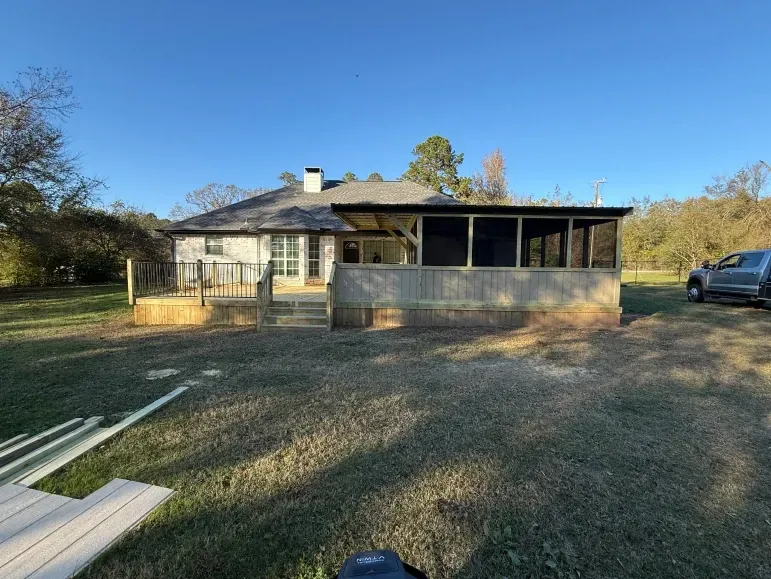 Single-story house with a screened porch on a grassy yard, viewed from the driveway.