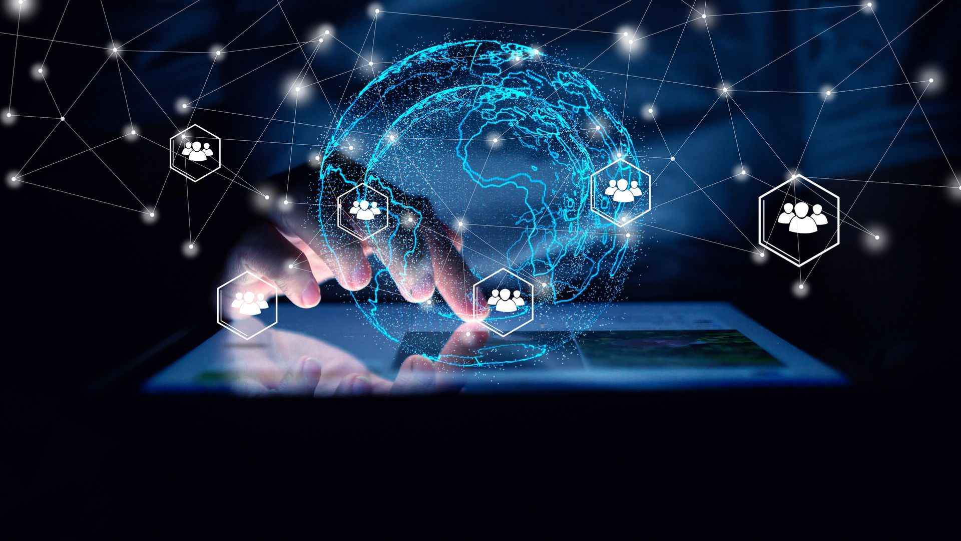 Hands typing on a glowing tablet with a blue digital globe and network icons above it