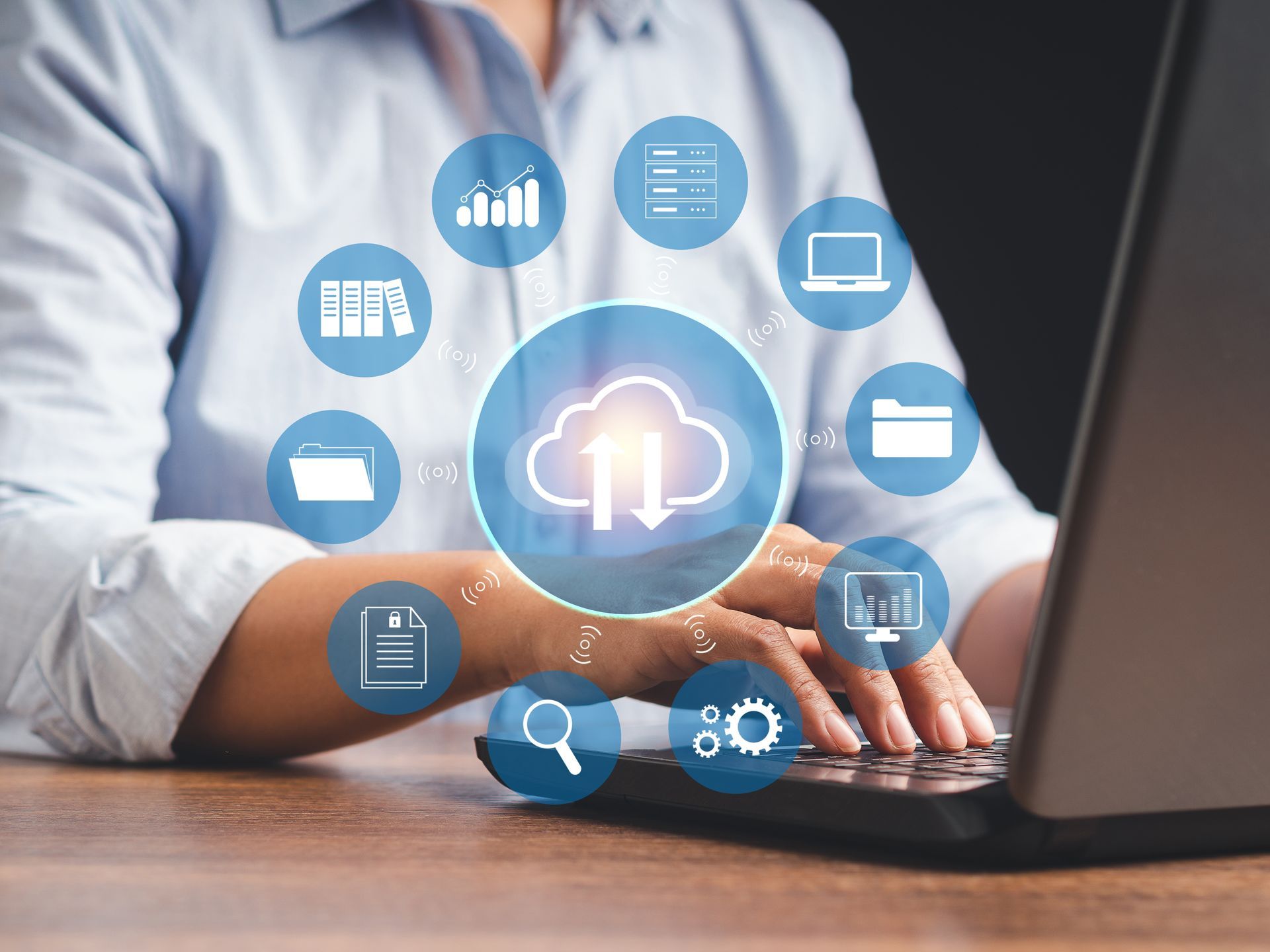 Hands typing on laptop with glowing cloud computing icons floating above the keyboard
