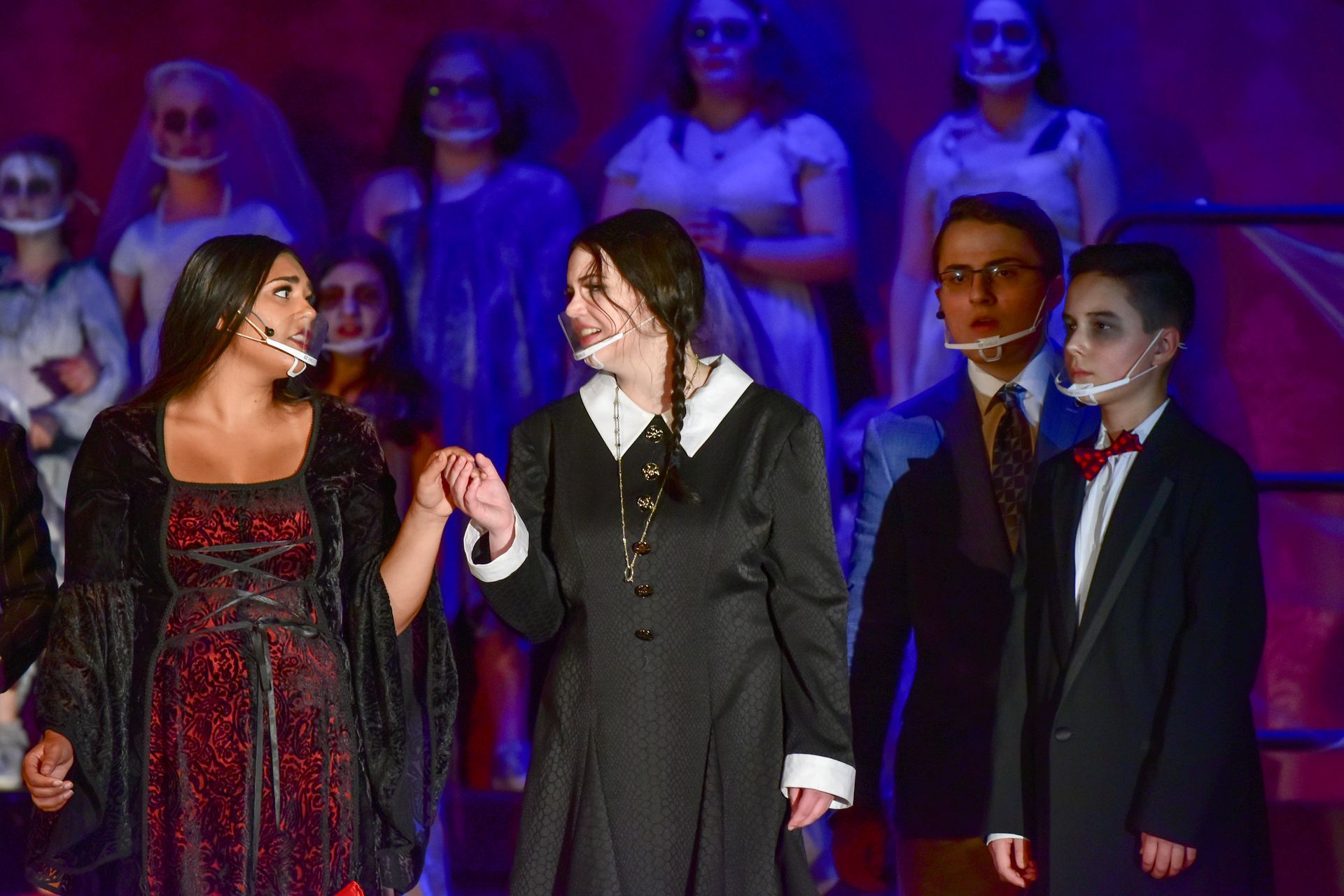 A theatrical production of The Addams Family with actors in costume on stage.