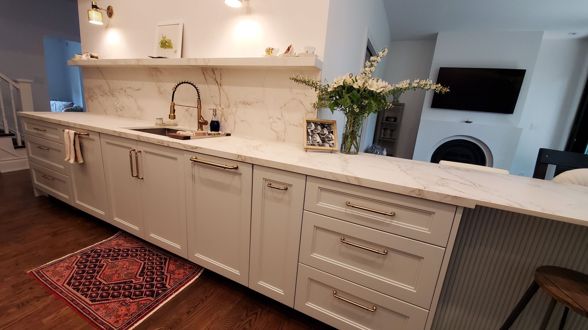 Kitchen with white countertops, gray cabinets, and a Persian rug.
