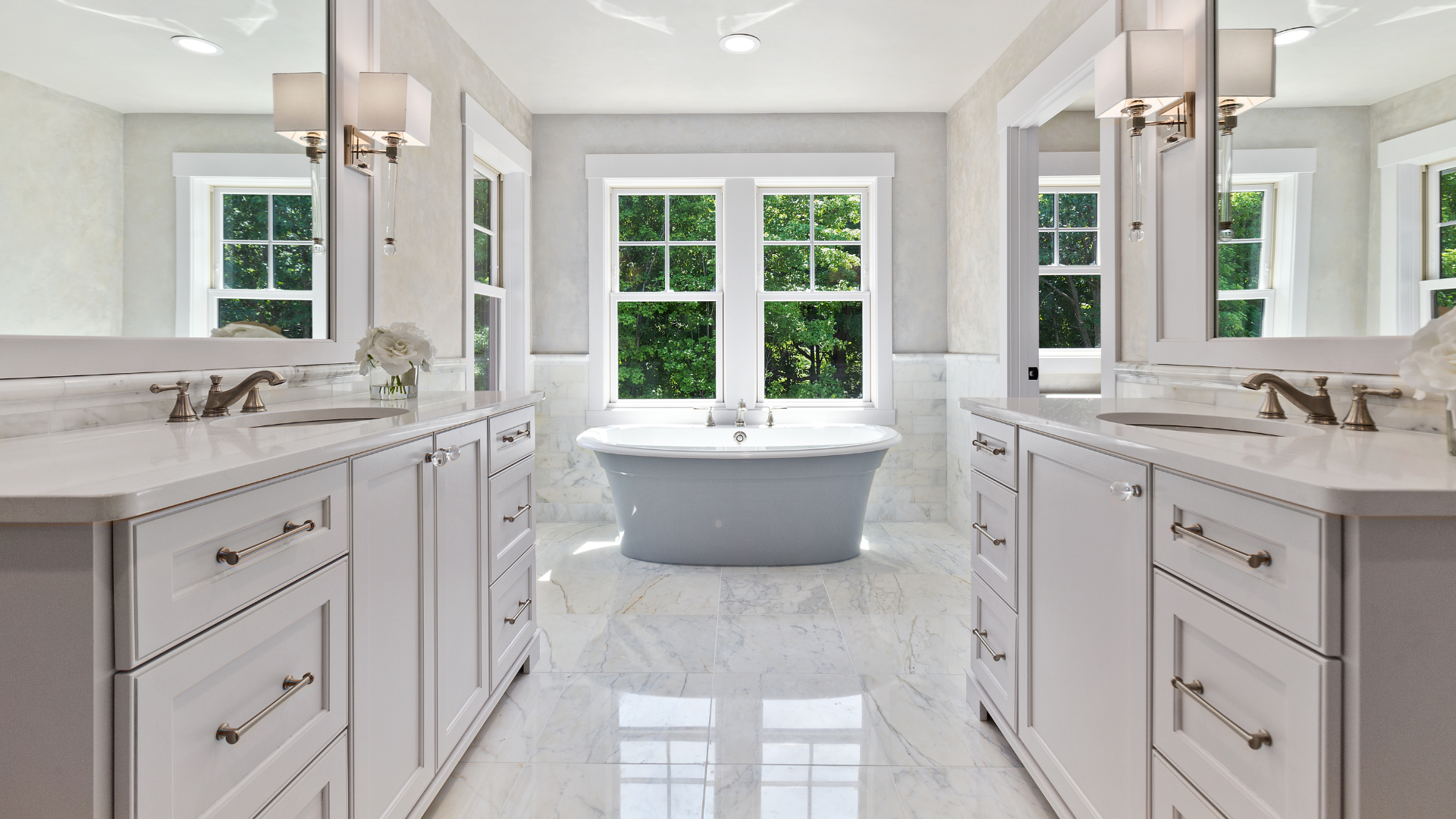 A bathroom with two sinks , two mirrors and a bathtub.