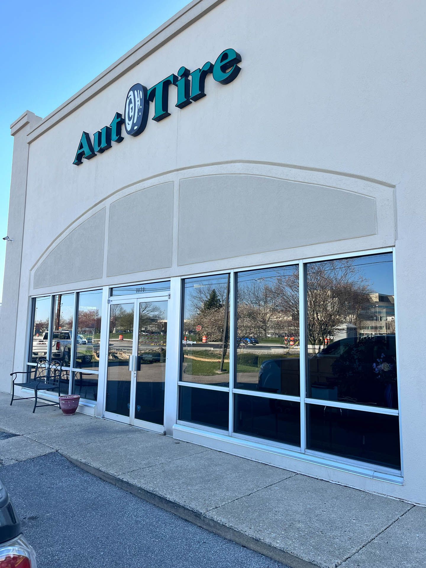 Auto Tire storefront with blue signage and large glass windows on a sunny day