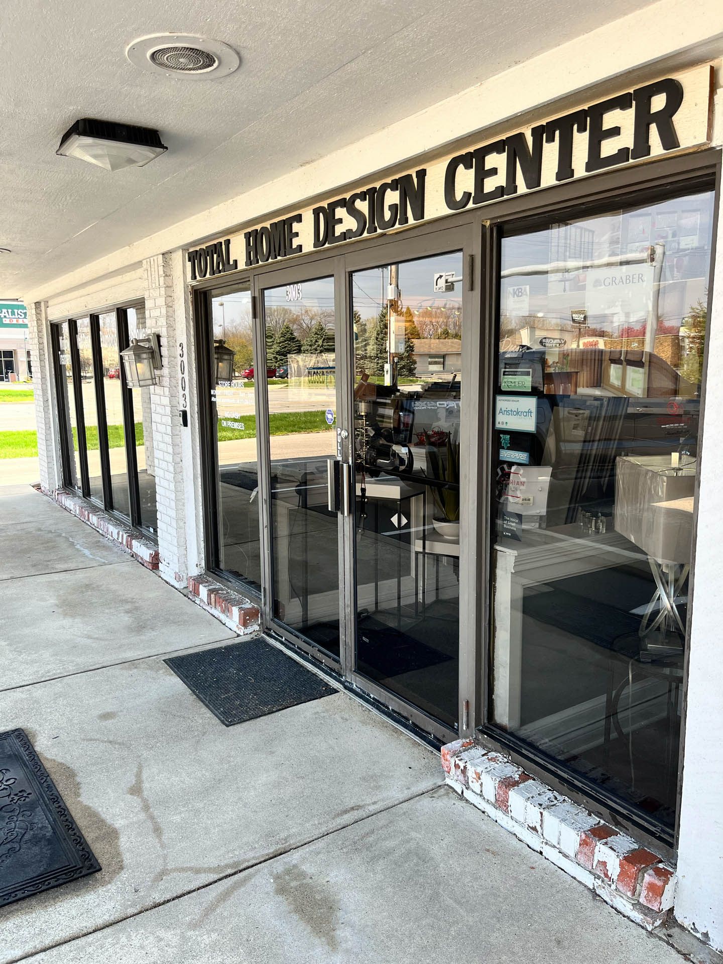 Exterior of a design center storefront with glass doors, brick accents, and sidewalk