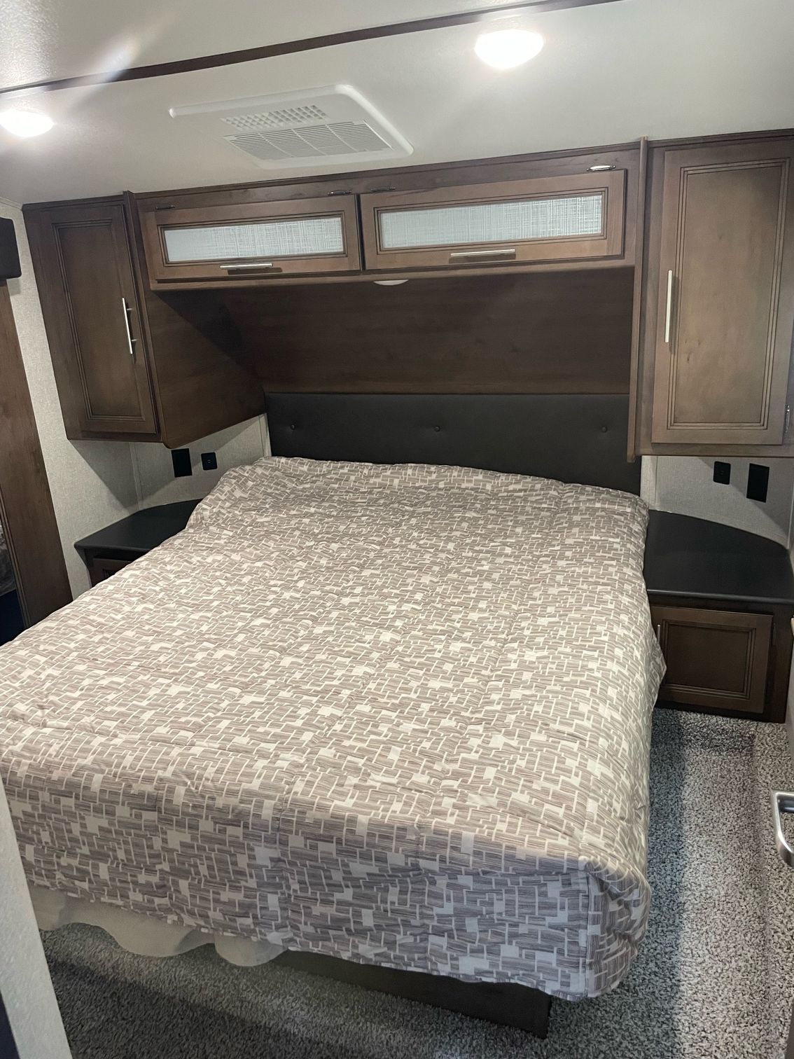 A bed in a rv with a blanket on it.
