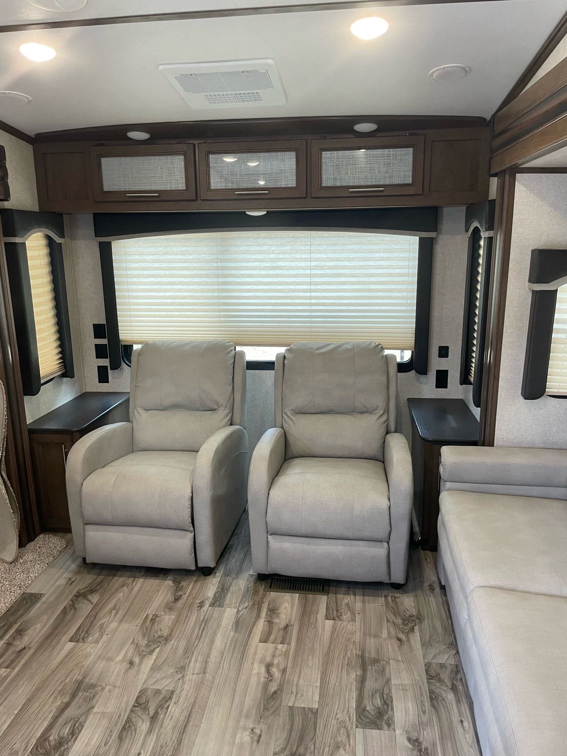 A living room with two recliner chairs and a couch.