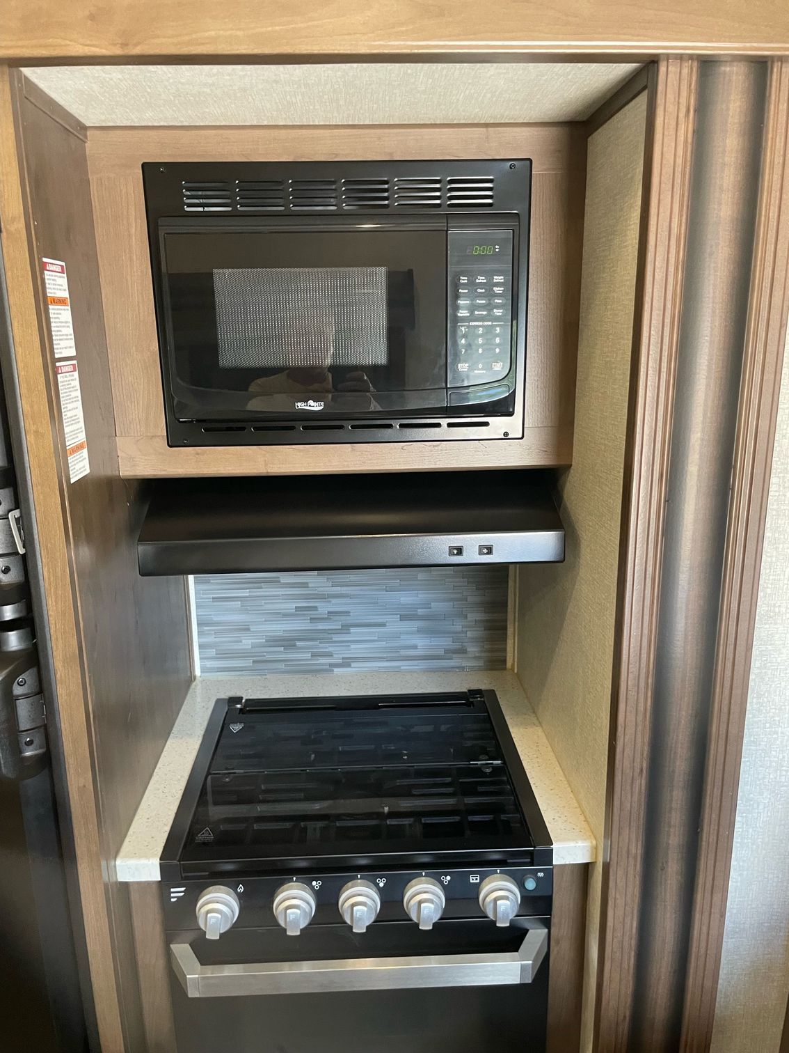 A stove top oven with a microwave above it.