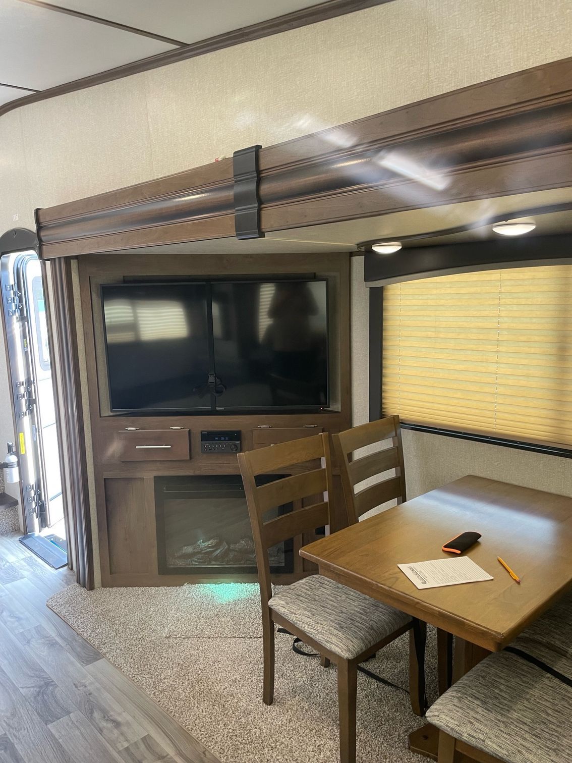 A living room with a table and chairs and a flat screen tv.