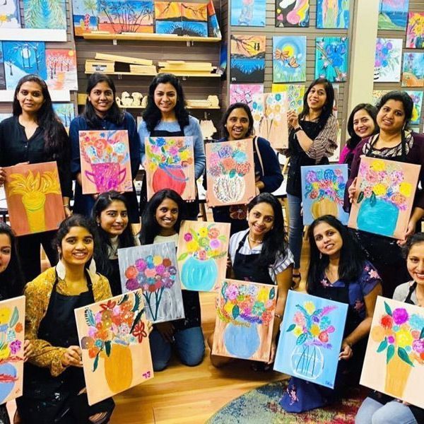 group of ladies holding their paintings