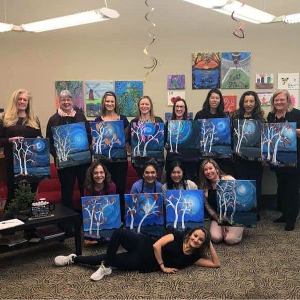 group photo of girls holding their paintings