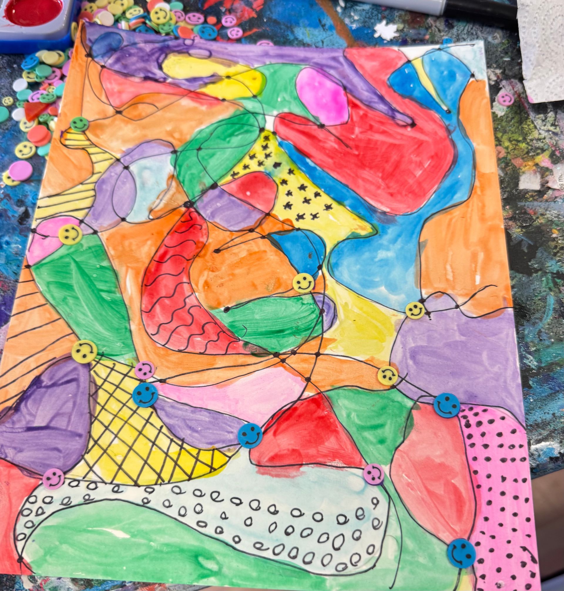 Colorful abstract painting with bold fish-like shapes, dots, and flowing pastel sections on paper