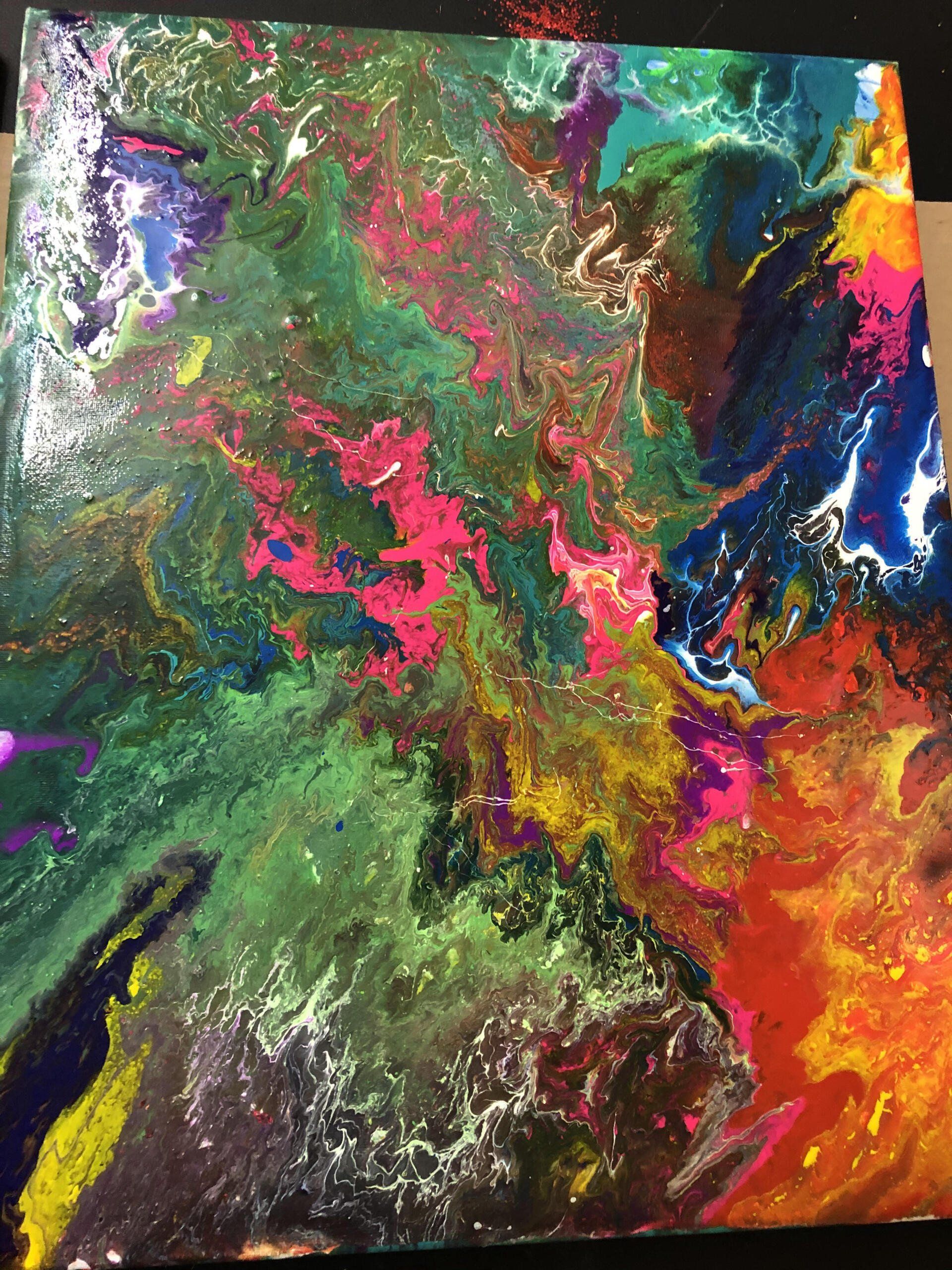 A close up of a colorful painting on a canvas on a table.