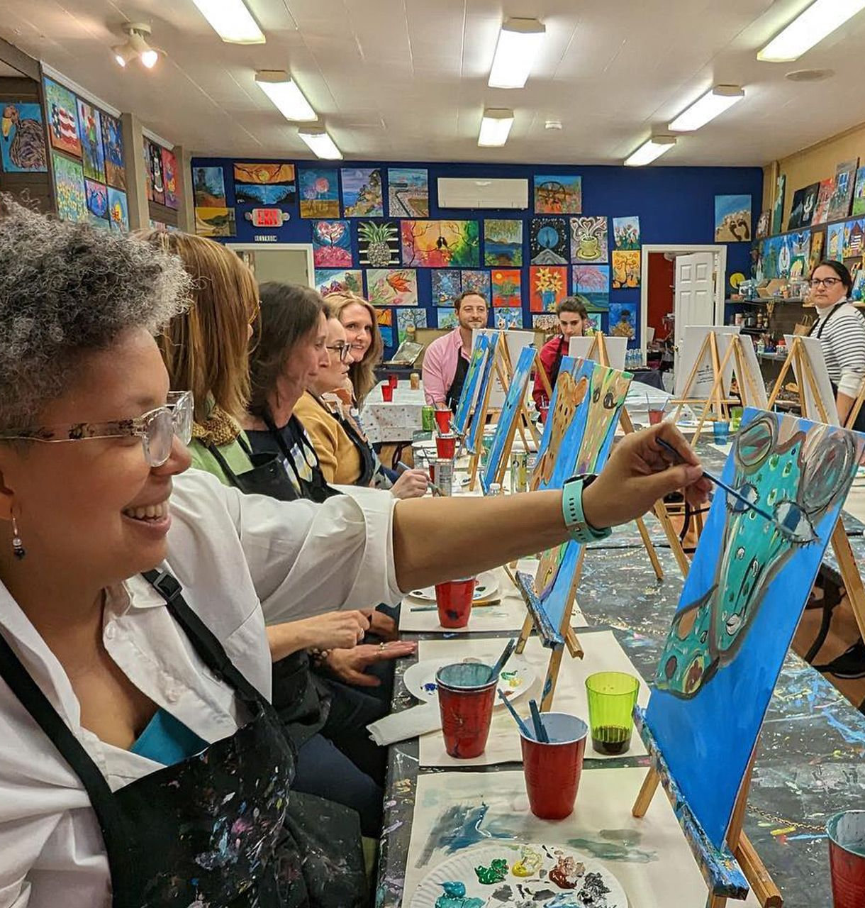 woman painting on canvas with headphones on