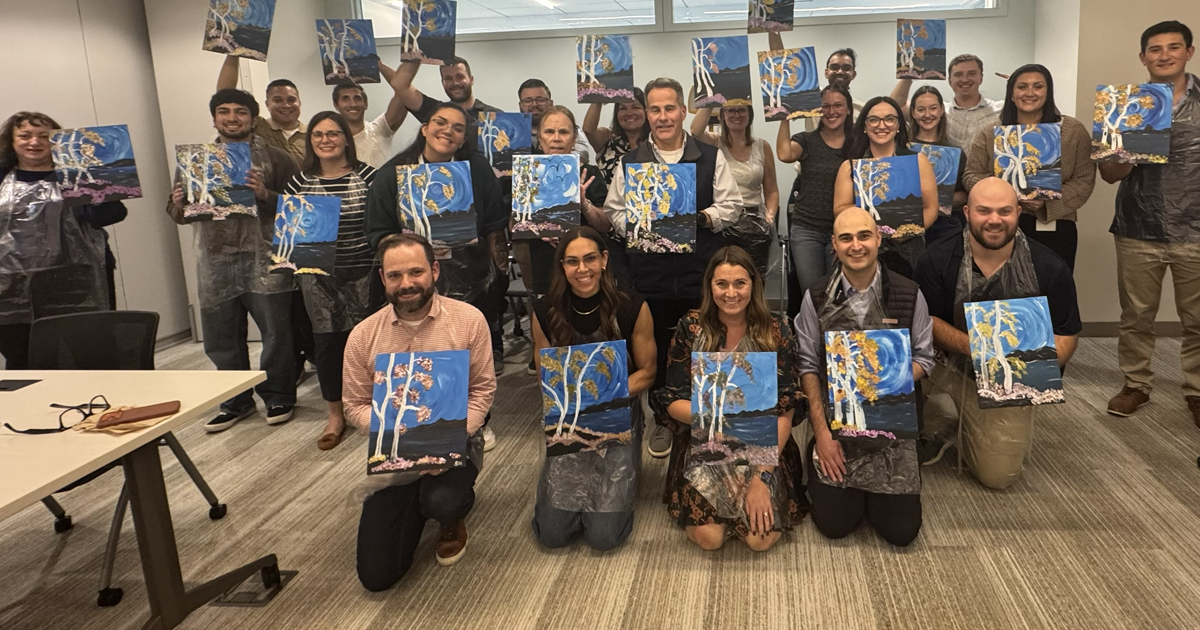 Boston Scientific employees holding painted canvases