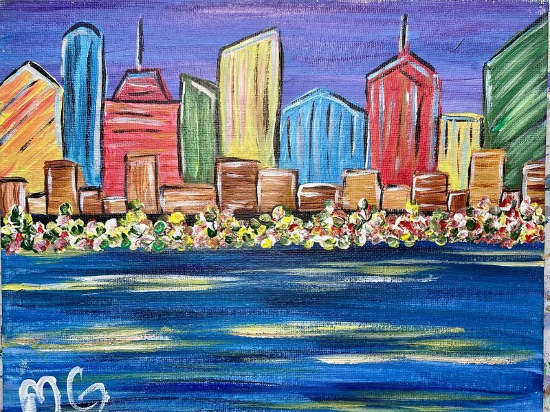 Colorful cityscape with skyscrapers against a purple sky, reflected in blue water.