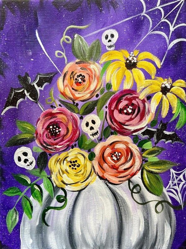 White pumpkin filled with colorful flowers, skulls, bats, and spiderwebs against a purple starry background.