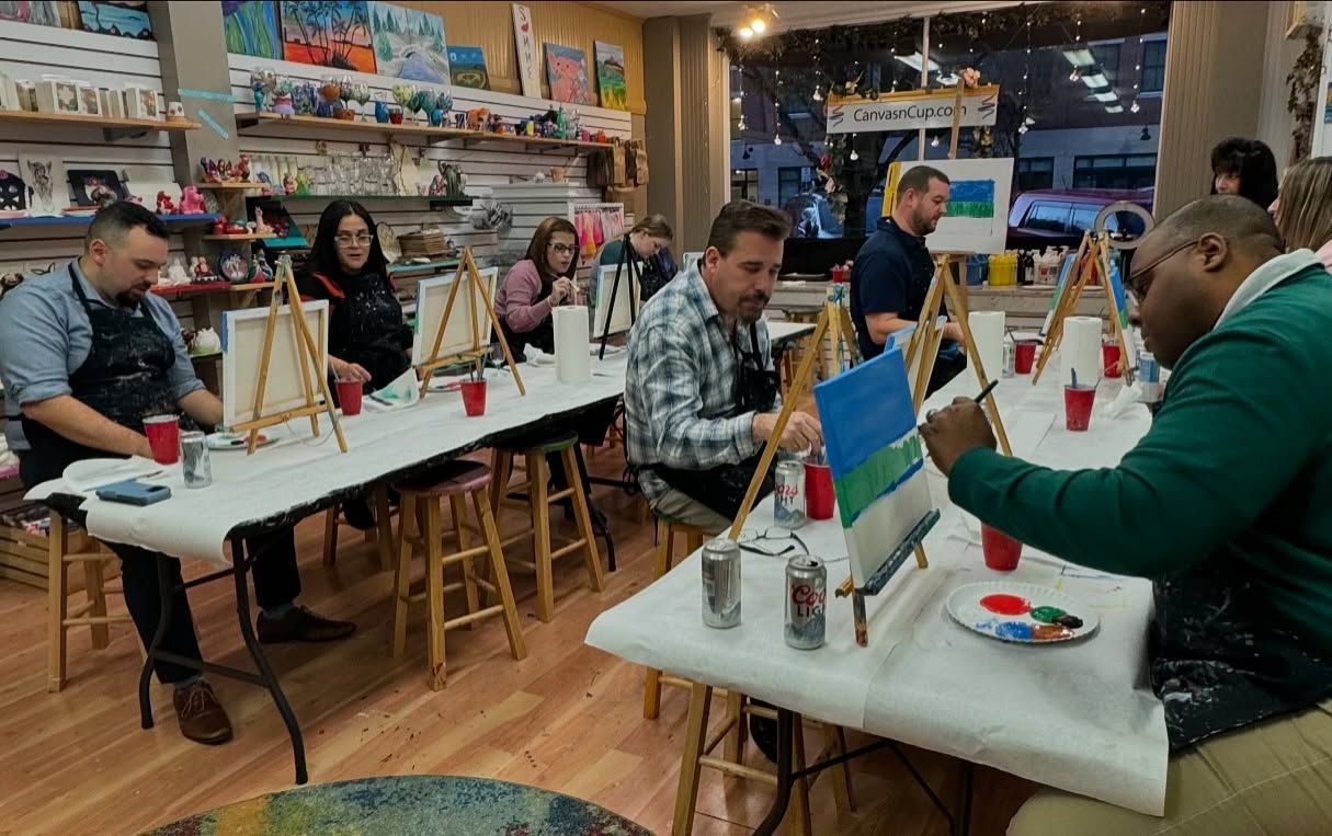 A group of people are sitting at tables painting.