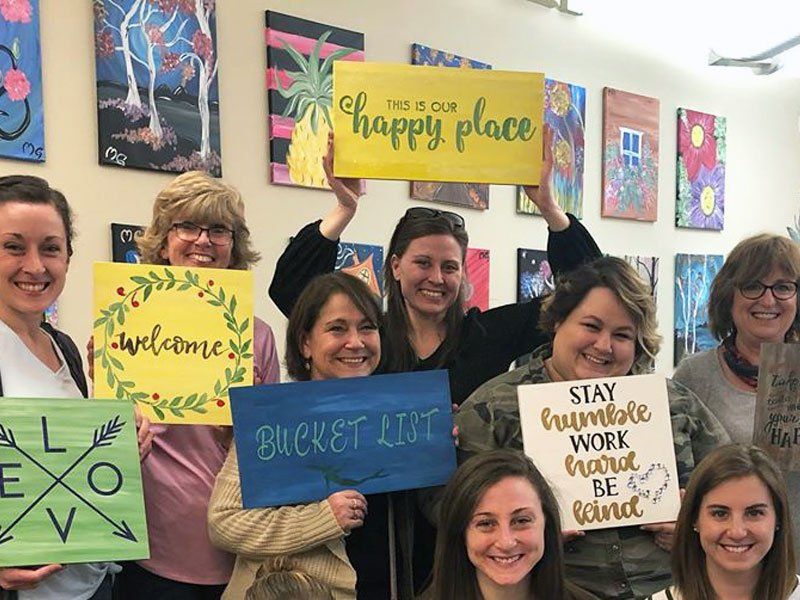 Group holding painted wood signs
