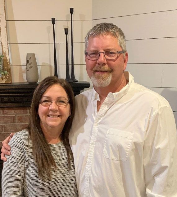 Plumber Dave and his wife Julie, standing next to each other and smiling