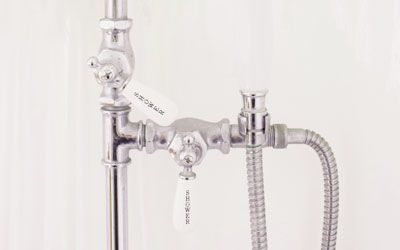 a close-up of a shower head fixture with a hose attached to it