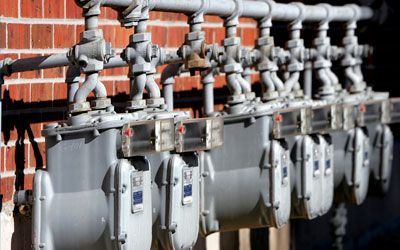 a bunch of gas pipes are attached to the exterior wall of a house
