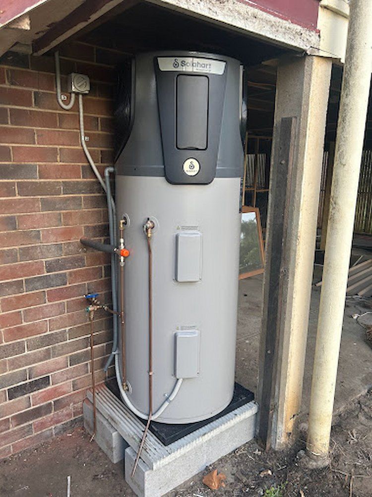 A Large Water Heater is Sitting on Top of a Brick Wall — Peak Plumbing and Gas Fitting in Yamba, NSW