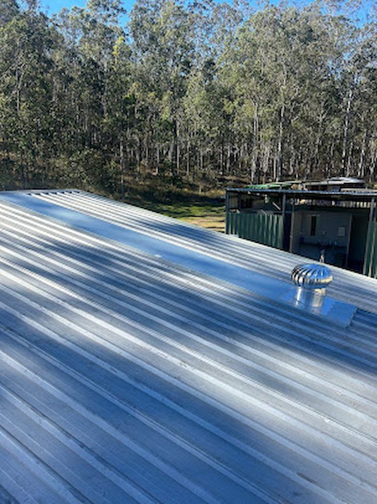 A Roof With a Vent on It and Trees in the Background — Peak Plumbing and Gas Fitting in Yamba, NSW