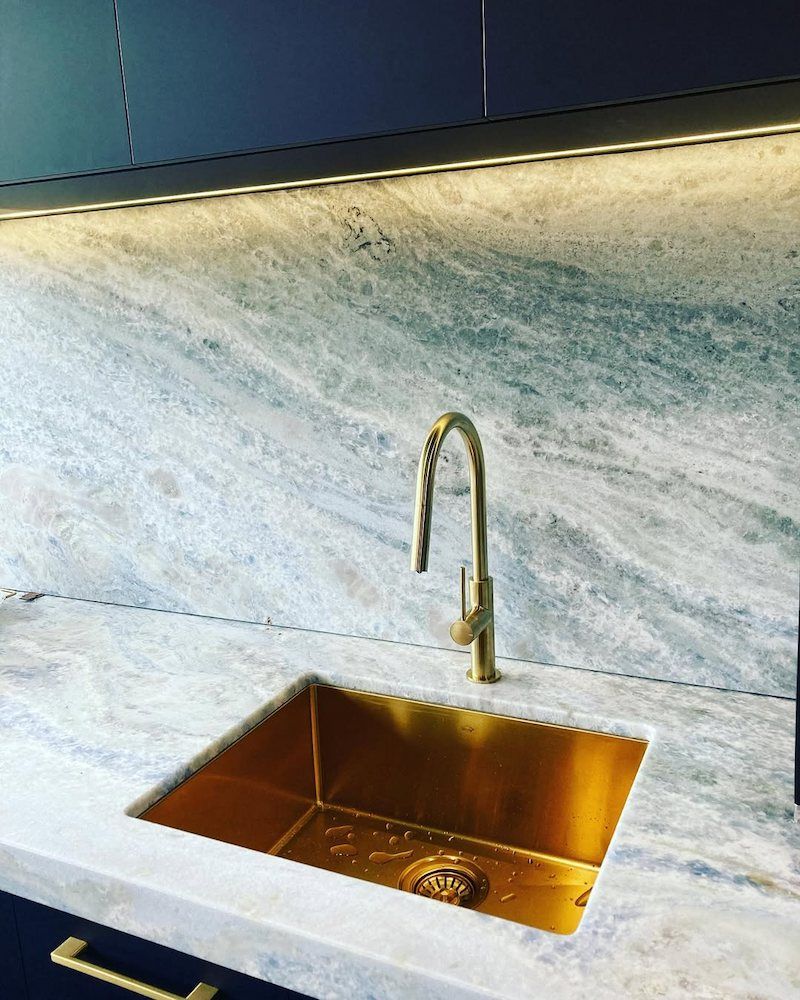 A Kitchen Sink With a Gold Faucet on a Marble Counter Top — Peak Plumbing and Gas Fitting in Yamba, NSW