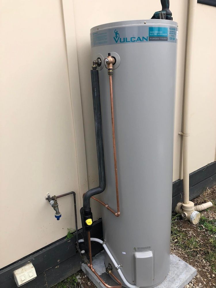 A Gray Water Heater is Sitting Outside of a Building — Peak Plumbing and Gas Fitting in Yamba, NSW