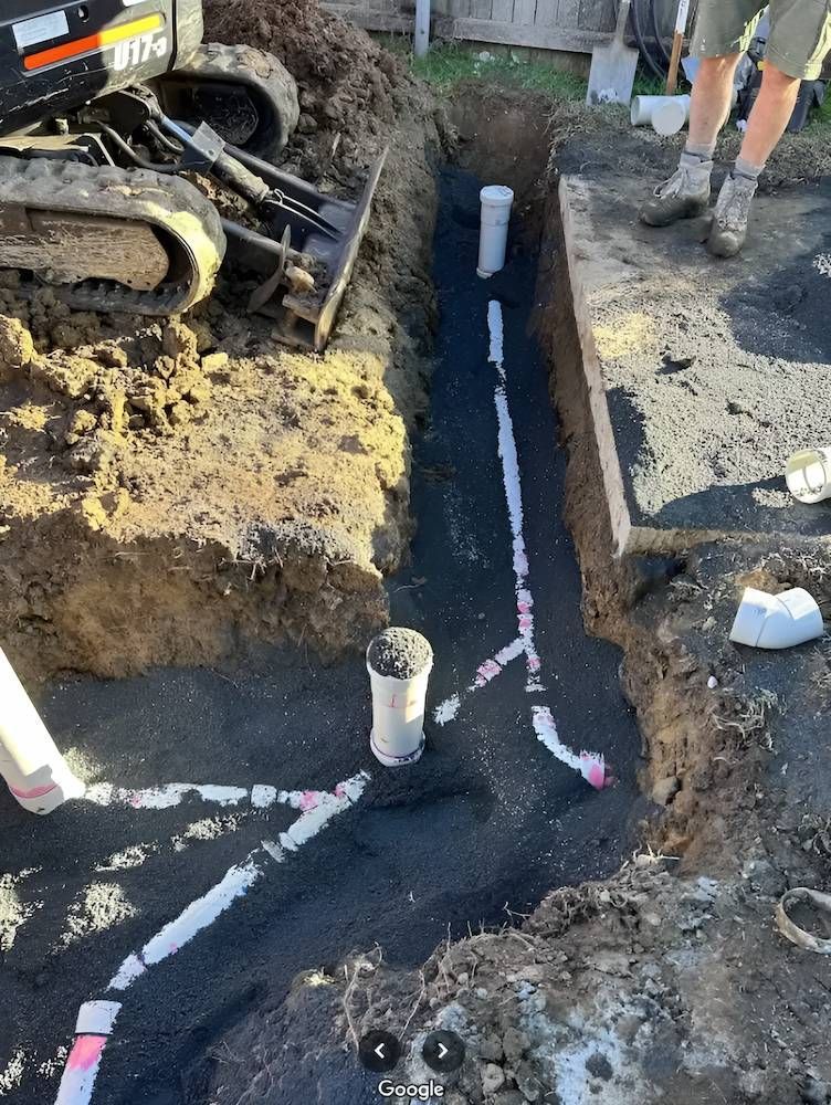 A Man is Digging a Hole in the Ground to Install a Pipe — Peak Plumbing and Gas Fitting in Yamba, NSW
