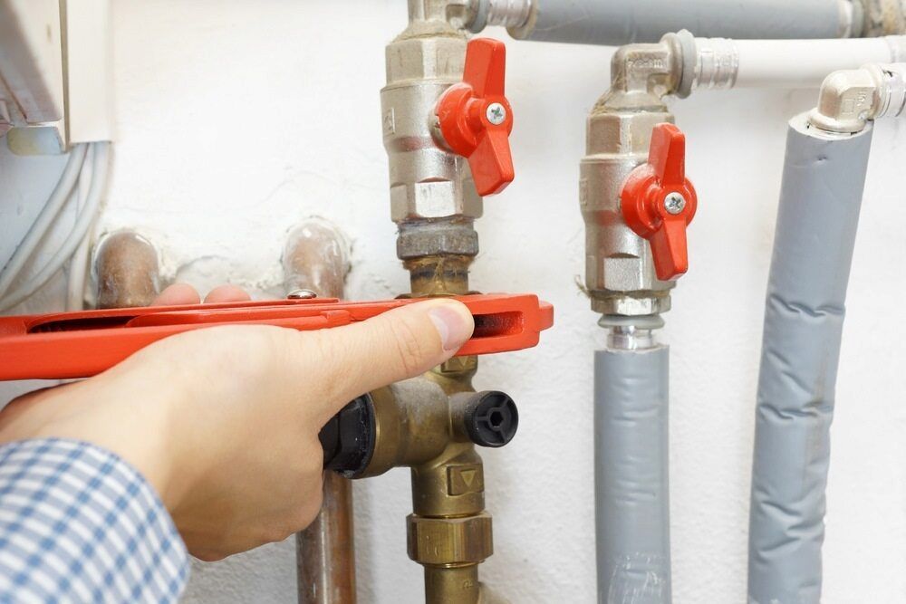 A Person is Fixing a Pipe With a Wrench — Peak Plumbing and Gas Fitting in Yamba, NSW