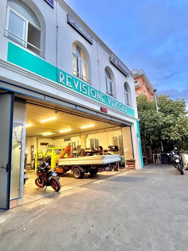 Scaffalatura per pneumatici in un garage, con file di pneumatici neri su ripiani blu e pavimento in cemento.