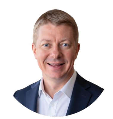 Studio headshot of a smiling man in a navy blazer and white shirt on a white background
