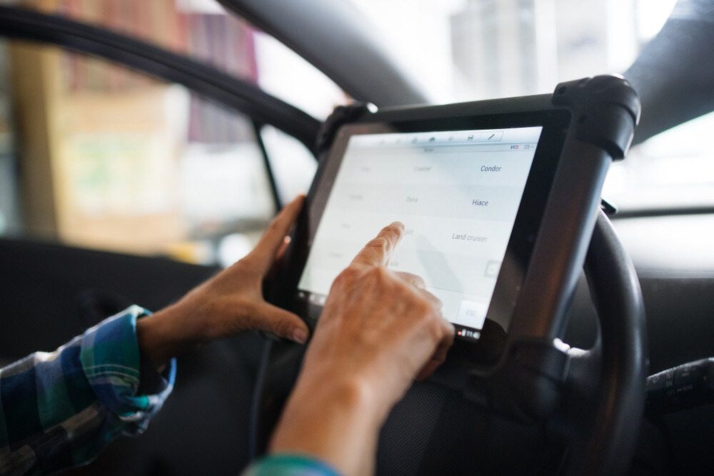 A Person is Using a Diagnostic Tool in a Car — Wayne's Mechanical World in Pialba, QLD