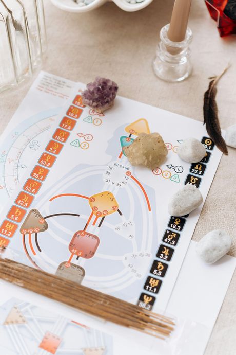 Handmade paper card with pumpkins and autumn leaves, surrounded by pinecones and small craft items