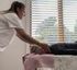 Person folding laundry beside a window with blinds in a softly lit room